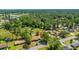 From an elevated perspective, a leafy neighborhood is highlighted; an arrow focuses on a dwelling tucked between green canopies at 565 Estates Dr, Walterboro, SC 29488