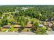 Aerial shot features a home nestled among lush greenery and other dwellings, set against a backdrop of dense forest at 565 Estates Dr, Walterboro, SC 29488
