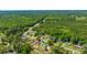 Extensive aerial view of a residential area set against a backdrop of a dense forest, showcasing a mix of homes at 565 Estates Dr, Walterboro, SC 29488