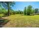 Wide backyard features mature trees and sparse grass with outdoor seating, ideal for relaxation and gatherings at 565 Estates Dr, Walterboro, SC 29488