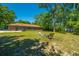Spacious backyard showcasing a fire pit area, mature trees, and the back exterior of the brick home at 565 Estates Dr, Walterboro, SC 29488
