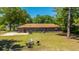 Aerial backyard view featuring a cozy firepit area with chairs, the rear of the brick home, and mature trees at 565 Estates Dr, Walterboro, SC 29488