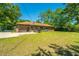 A view of the exterior back of the property with a large grass area at 565 Estates Dr, Walterboro, SC 29488