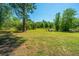 Expansive backyard featuring mature trees, green grass and a cozy seating area, perfect for outdoor entertaining at 565 Estates Dr, Walterboro, SC 29488