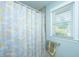 Bright bathroom features a shower with decorative curtain and a window at 565 Estates Dr, Walterboro, SC 29488