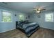 This large bedroom features 3 windows, a ceiling fan, and wood flooring at 565 Estates Dr, Walterboro, SC 29488