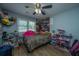 Charming bedroom with wood floor, ceiling fan, toys, and lots of natural light at 565 Estates Dr, Walterboro, SC 29488