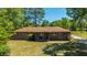 Full exterior view of a charming brick home with a well-maintained yard and a welcoming front porch with seating at 565 Estates Dr, Walterboro, SC 29488
