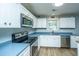 The kitchen boasts stainless steel appliances, white cabinets, and ample countertop space for cooking at 565 Estates Dr, Walterboro, SC 29488