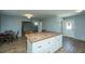 Kitchen island in the home with butcher block countertop, storage, and opening to the dining area at 565 Estates Dr, Walterboro, SC 29488