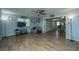 Inviting living room featuring a ceiling fan, wood-look floors, and a view into the kitchen at 565 Estates Dr, Walterboro, SC 29488