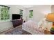 Cozy bedroom featuring two bright windows, a vintage wood dresser, and a plush patterned bedding set at 6 Sayle Rd, Charleston, SC 29407