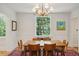 Bright dining room with a window view, chandelier, wooden table, and Persian-style rug on hardwood floors at 6 Sayle Rd, Charleston, SC 29407