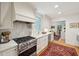 Well-lit kitchen with stainless steel appliances, white cabinets, hardwood floors, and a view into another room at 6 Sayle Rd, Charleston, SC 29407