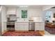 Charming kitchen featuring stainless steel appliances, white cabinets, hardwood floors, and Persian style rug at 6 Sayle Rd, Charleston, SC 29407