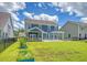 Large backyard featuring lush grass, a screened porch, and a patio with a fire pit at 602 Yellow Leaf Ln, Summerville, SC 29486