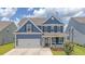 Attractive two-story home with a garage, inviting front porch, and landscaped yard at 602 Yellow Leaf Ln, Summerville, SC 29486