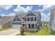 Charming two-story home with blue siding, black shutters, a front-facing two-car garage, and a well-manicured lawn at 602 Yellow Leaf Ln, Summerville, SC 29486