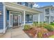 Inviting front porch with a decorated door, stylish lighting, and lush landscaping at 602 Yellow Leaf Ln, Summerville, SC 29486