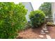 Landscaped backyard with a stone pathway, lush greenery, and a charming picket fence, enhancing the home's curb appeal at 708 Lawton Harbor Dr, Charleston, SC 29412