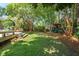 Lush backyard featuring a well-maintained lawn, wooden deck, mature trees, and a playhouse for outdoor enjoyment at 708 Lawton Harbor Dr, Charleston, SC 29412