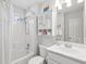 White bathroom with tub shower combo, storage, and an artful mirror above the sink at 708 Lawton Harbor Dr, Charleston, SC 29412