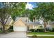 Inviting home with lush green lawn, mature trees, and attached two-car garage at 708 Lawton Harbor Dr, Charleston, SC 29412