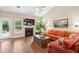 Bright living room with a fireplace, large windows, and a comfortable orange sofa, perfect for relaxation and entertaining at 708 Lawton Harbor Dr, Charleston, SC 29412