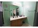 Mint green bathroom featuring a large mirror, dark wood vanity, and a neutral-colored tile floor at 714 Alwyn Blvd, Summerville, SC 29485