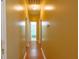 Long hallway with hardwood floors and yellow painted walls with multiple doors at 714 Alwyn Blvd, Summerville, SC 29485