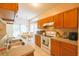 Kitchen features wood cabinets, white appliances, tile flooring, and a view of the dining area at 714 Alwyn Blvd, Summerville, SC 29485