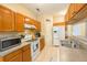 Kitchen featuring wooden cabinets, stainless steel sink, and white appliances at 714 Alwyn Blvd, Summerville, SC 29485