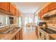 Bright kitchen with tile floors, wooden cabinets, and a dining area in the background at 714 Alwyn Blvd, Summerville, SC 29485