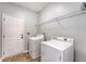 Well-lit laundry room featuring modern, white washer and dryer, plus wire shelving for storage at 801 Long Drive Rd, Summerville, SC 29485