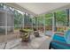 Comfortable screened-in porch with wicker furniture overlooking a well-maintained backyard and landscaping at 801 Long Drive Rd, Summerville, SC 29485