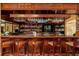 Elegant wooden bar with stocked shelves, hanging glassware, and comfortable seating for a luxurious experience at 8725 Herons Walk, North Charleston, SC 29420