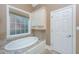 Soaking tub with tile surround, built-in cabinets, and a window for natural light at 8725 Herons Walk, North Charleston, SC 29420