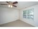 Bedroom featuring a ceiling fan, neutral carpet, a window with blinds, and a door at 8725 Herons Walk, North Charleston, SC 29420