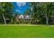 Two-story brick home surrounded by lush lawn, mature trees, and manicured landscaping at 8725 Herons Walk, North Charleston, SC 29420