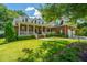 Well-maintained home with a covered porch, lush lawn, and mature trees creating curb appeal at 8725 Herons Walk, North Charleston, SC 29420