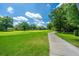 Beautiful golf course view with lush green grass, mature trees, and a paved path on a sunny day at 8725 Herons Walk, North Charleston, SC 29420