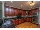 Well-equipped kitchen with dark wood cabinets, granite countertops, and stainless steel appliances at 8725 Herons Walk, North Charleston, SC 29420