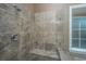 Walk-in shower that features tiled walls, built-in bench, and a window for natural light at 8725 Herons Walk, North Charleston, SC 29420