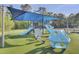 Community playground area with slides, climbing structure and swings, covered by a large blue awning at 9016 Greenbriar Dr, Summerville, SC 29485
