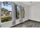 Well-lit sunroom showing gray floors, white walls, windows, and a view of the green space at 902 Greenmeadow Dr, Goose Creek, SC 29445