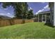 A fully fenced backyard features green grass, privacy fence, and a screened in back porch at 9680 Spencer Woods Rd, Ladson, SC 29456