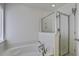 Bright bathroom with a soaking tub, separate glass shower, and neutral tile flooring at 9680 Spencer Woods Rd, Ladson, SC 29456