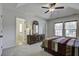 Bright bedroom featuring a ceiling fan, tray ceiling, neutral carpet, and an ornate wood dresser at 9680 Spencer Woods Rd, Ladson, SC 29456