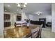 Inviting dining area with a wooden table, chandelier, and a view of the adjacent living room and kitchen at 9680 Spencer Woods Rd, Ladson, SC 29456