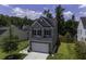 Exterior view of home with two-car garage, driveway, and a mature shade tree in the front yard at 9680 Spencer Woods Rd, Ladson, SC 29456